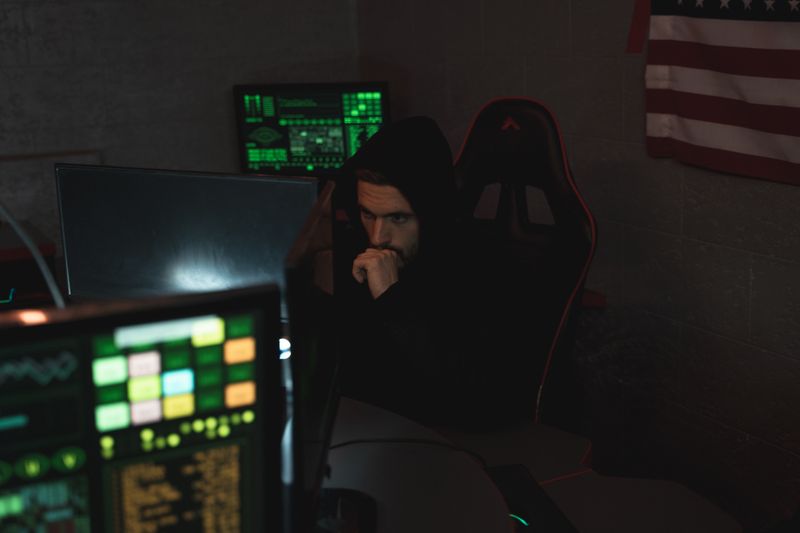 Security analyst monitoring multiple screens in a dark room