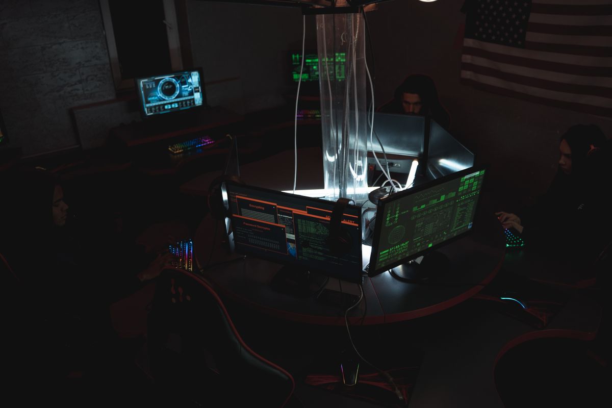 Cybersecurity team collaborating in a darkened operations room with multiple monitors